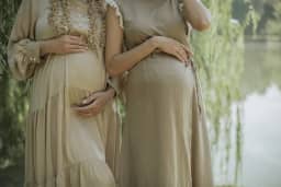 Two pregnant women side by side, with their hands on their bellies